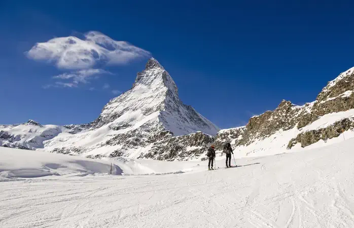 Alpine Touring Skiers ,Swiss Alps. In background the peak of Matterhorn. Swiss-Italy border