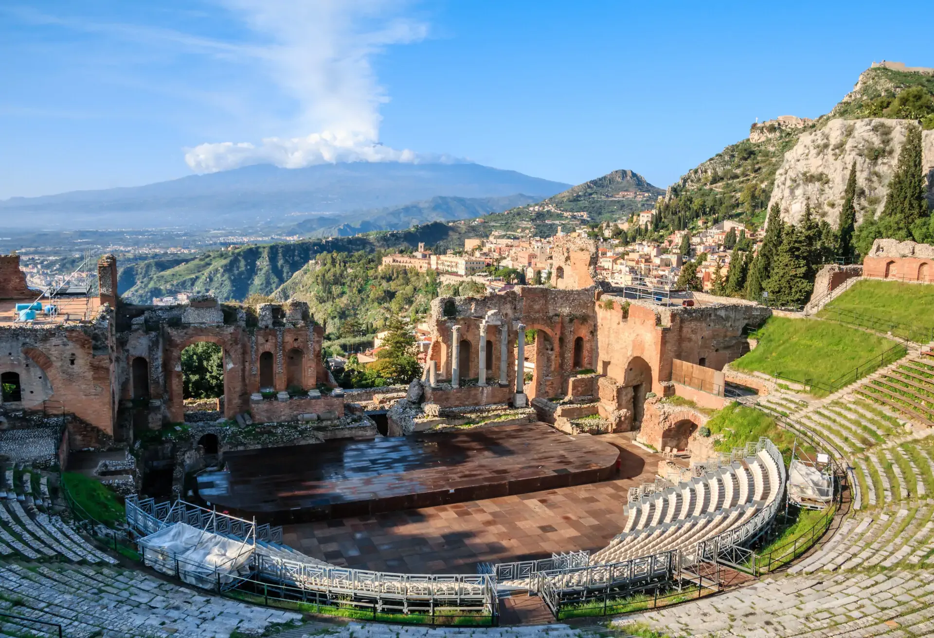 The Greek theatre with smoking Mount Etna volcano in the background, Taormina, Sicily, Italy.